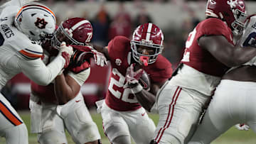 Nov 30, 2024; Tuscaloosa, Alabama, USA;  Alabama Crimson Tide running back Justice Haynes (22) runs behind offensive lineman Parker Brailsford (72) and offensive lineman Tyler Booker (52) against the Auburn Tigers during the second half at Bryant-Denny Stadium. Alabama won 28-14. Mandatory Credit: Gary Cosby Jr.-Imagn Images