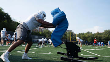 Kansas redshirt senior offensive lineman Enrique Cruz Jr. (77) pushes against a sled during practice at the Murfin Family Practice Fields on Aug. 8, 2025.