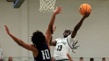 Jacksonville Dolphins guard Robert McCray V (13) drives the lane against North Florida Ospreys forward Josh Harris (10) during the first half of an NCAA men’s basketball matchup Saturday, Feb. 1, 2025 at Jacksonville University in Jacksonville, Fla. [Corey Perrine/Florida Times-Union]