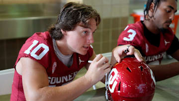 Oklahoma Sooners quarterback John Mateer (10) signs a helmet for a fan during Meet the Sooners Day at Gaylord Family Ñ Oklahoma Memorial Stadium, Saturday, Aug. 2, 2025.