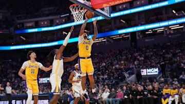 Oct 18, 2024; San Francisco, California, USA; Los Angeles Lakers guard Jalen Hood-Schifino (0) makes a basket in front of Golden State Warriors forward Kevon Looney (5) in the second quarter at the Chase Center. Mandatory Credit: Cary Edmondson-Imagn Images
