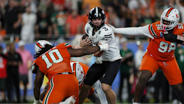 aDec 28, 2024; Orlando, FL, USA; Iowa State Cyclones quarterback Rocco Becht (3) is pressured by Miami Hurricanes defensive lineman Simeon Barrow Jr. (10) in the fourth quarter during the Pop Tarts bowl at Camping World Stadium. Mandatory Credit: Nathan Ray Seebeck-Imagn Images