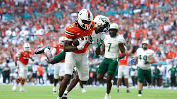 Sep 13, 2025; Miami Gardens, Florida, USA; Miami Hurricanes wide receiver Joshua Moore (3) holds off South Florida Bulls cornerback Ben Knox (1) for a touchdown in the first quarter in the first quarter  at Hard Rock Stadium. Mandatory Credit: Nathan Ray Seebeck-Imagn Images