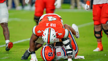 Nov 8, 2025; Miami Gardens, Florida, USA; Syracuse Orange quarterback Rickie Collins (10) is sacked by Miami Hurricanes defensive lineman Rueben Bain Jr. (4) during the fourth quarter at Hard Rock Stadium. Mandatory Credit: Jeff Romance-Imagn Images