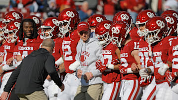 Oklahoma coach Brent Venables locks arms and walks with his team before a college football game