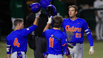 Florida catcher Brody Donay (29) taps helmets with infielder Cade Kurland (4) and infielder Brendan Lawson (11) after a solo home run during the fifth inning of an NCAA baseball matchup Monday, Feb. 17, 2025 at Jacksonville University in Jacksonville, Fla. Florida defeated Jacksonville 10-4. [Corey Perrine/Florida Times-Union]