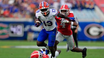 Florida Gators running back Jadan Baugh (13) fends off Georgia Bulldogs defensive back KJ Bolden (4) during the second quarter of an NCAA college football matchup Saturday, Nov. 2, 2024 at EverBank Stadium in Jacksonville, Fla. The Georgia Bulldogs defeated the Florida Gators 34-20. [Corey Perrine/Florida Times-Union]