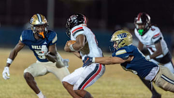 West Boca's Jaydin Broadnax, left, cuts off Southridge running back Shandon Smith as Maxwell Reid, tackles him during their state semifinal game on December 6, 2024, in Boca Raton, Florida.