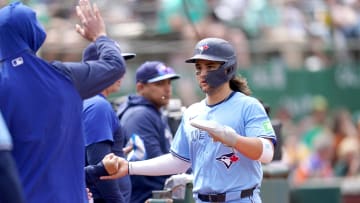 Jun 8, 2024; Oakland, California, USA; Toronto Blue Jays shortstop Bo Bichette (11) is congratulated by teammates after scoring a run against the Oakland Athletics in the ninth inning at Oakland-Alameda County Coliseum. Mandatory Credit: Cary Edmondson-USA TODAY Sports