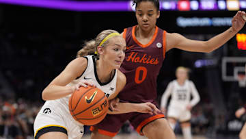 Nov 10, 2024; Charlotte, NC, USA; Iowa Hawkeyes guard Kylie Feuerbach (4) drives to the basket against Virginia Tech Hokies guard Lani White (0) during the first half at Spectrum Center. Mandatory Credit: Jim Dedmon-Imagn Images