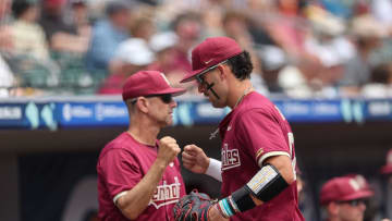 May 25, 2024; Charlotte, NC, USA; Florida State first baseman Daniel Cantu (32) fist bumps Florida State head coach Link Jarrett.