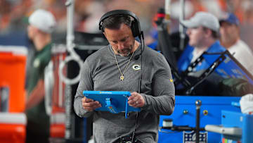 Aug 18, 2024; Denver, Colorado, USA; Green Bay Packers linebackers coach Anthony Campanile looks at a tablet in the second half against the Denver Broncos at Empower Field at Mile High. 