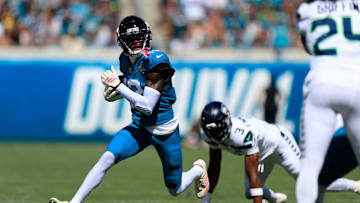 Jacksonville Jaguars wide receiver Travis Hunter (12) rushes for yards against Seattle Seahawks safety Nick Emmanwori (3) during the first quarter of an NFL football matchup, Sunday, Oct. 12, 2025, at EverBank Stadium in Jacksonville, Fla.