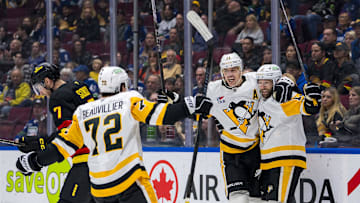 Oct 26, 2024; Vancouver, British Columbia, CAN; Vancouver Canucks defenseman Carson Soucy (7) reacts as Pittsburgh Penguins forward Anthony Beauvillier (72) and forward Evgeni Malkin (71) and forward Bryan Rust (17) celebrate Rust’s goal during the second period at Rogers Arena. Mandatory Credit: Bob Frid-Imagn Images