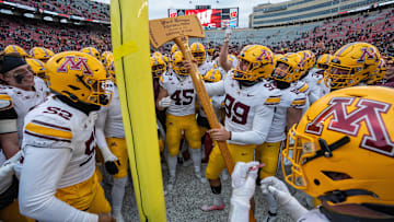 Minnesota players pretend to cutdown the goal post with the Paul Bunyan Football Trophy after their game at Camp Randall Stadium Friday, November 29, 2024 in Madison, Wisconsin. Minnesota beat Wisconsin 24-7.