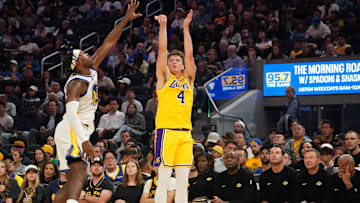 Oct 5, 2025; San Francisco, California, USA;  Los Angeles Lakers forward Dalton Knecht (4) shoots while defended by Golden State Warriors guard Buddy Hield (7) in the second quarter at Chase Center. Mandatory Credit: David Gonzales-Imagn Images