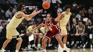 Dec 2, 2025; Winston-Salem, North Carolina, USA; Wake Forest Demon Deacons guard Nate Calmese (1) passes the ball defended by Oklahoma Sooners guard Nijel Pack (9) during the second half at Lawrence Joel Veterans Memorial Coliseum. Mandatory Credit: Jim Dedmon-Imagn Images