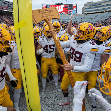 Minnesota players pretend to cutdown the goal post with the Paul Bunyan Football Trophy after their game at Camp Randall Stadium Friday, November 29, 2024 in Madison, Wisconsin. Minnesota beat Wisconsin 24-7.