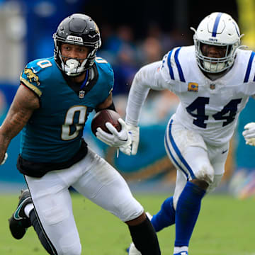 Jacksonville Jaguars wide receiver Gabe Davis (0) rushes for yards between Indianapolis Colts cornerback Jaylon Jones (40) and cornerback Chris Lammons (35) during the second quarter of an NFL football matchup Sunday, Oct. 6, 2024 at EverBank Stadium in Jacksonville, Fla. The Jaguars edged the Colts on a field goal 37-34. [Corey Perrine/Florida Times-Union]