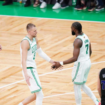 Jun 6, 2024; Boston, Massachusetts, USA; Boston Celtics center Kristaps Porzingis (8) and guard Jaylen Brown (7) and forward Jayson Tatum (0) react in the second quarter against the Dallas Mavericks during game one of the 2024 NBA Finals at TD Garden. Mandatory Credit: David Butler II-USA TODAY Sports