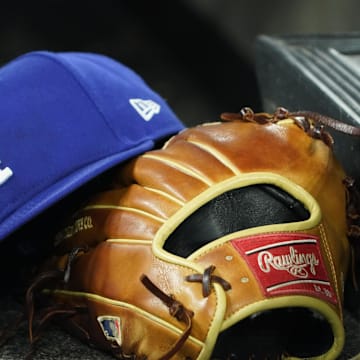 Apr 28, 2024; Toronto, Ontario, CAN; A hat and glove of an Los Angeles Dodgers player durng a game against the Toronto Blue Jays at Rogers Centre. Mandatory Credit: John E. Sokolowski-Imagn Images