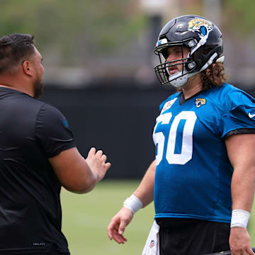 Jacksonville Jaguars assistant offensive line/run game specalist Keli'i Kekuewa, left, talks technique with center Jonah Monheim (60) during a rookie minicamp at Miller Electric Center Saturday, May 10, 2025 in Jacksonville, Fla. [Corey Perrine/Florida Times-Union]
