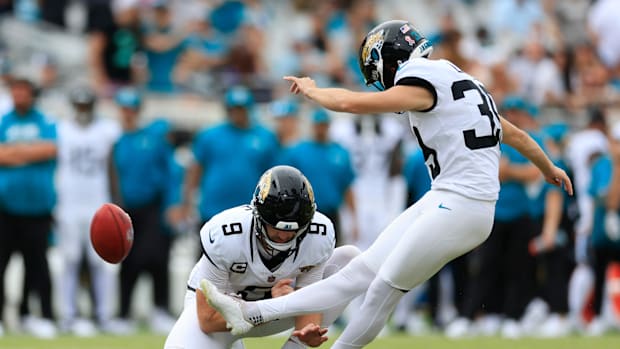 Jacksonville Jaguars place kicker Cam Little (39) kicks a field goal as punter Logan Cooke (9) holds.