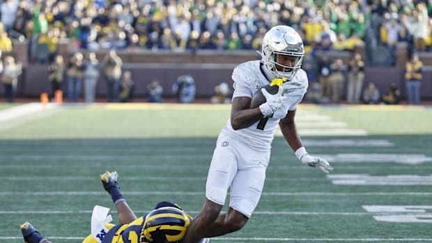 Oregon Ducks wide receiver Evan Stewart (7) is tackled by Michigan Wolverines defensive back Aamir Hall (12)