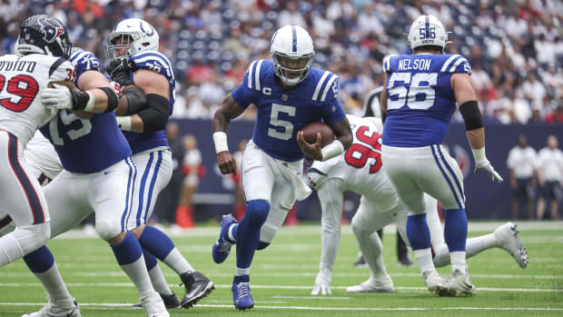 Football player Anthony Richardson runs with the ball in a blue jersey.