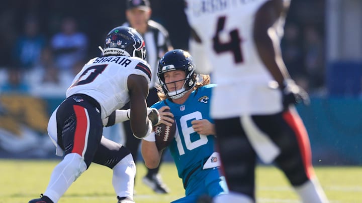 Jacksonville Jaguars quarterback Trevor Lawrence (16) slides for a down as Houston Texans linebacker Azeez Al-Shaair (0) makes a late hit during the second quarter of an NFL football matchup Sunday, Dec. 1, 2024 at EverBank Stadium in Jacksonville, Fla. [Corey Perrine/Florida Times-Union]