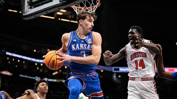 Mar 13, 2026; Kansas City, MO, USA; Kansas Jayhawks guard Kohl Rosario (7) rebounds around Houston Cougars forward Kalifa Sakho (14) during the second half at T-Mobile Center. Mandatory Credit: William Purnell-Imagn Images
