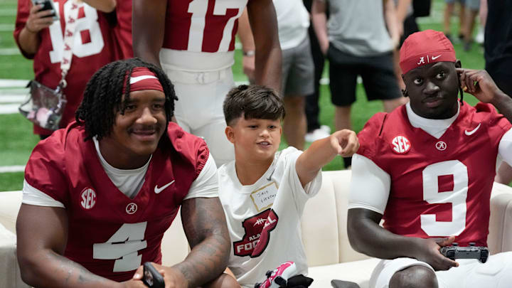 Aug. 4, 2025; Tuscaloosa, AL, USA; Alabama Crimson Tide players and coaches participate in a media day with reporters and fans at the Hank Crisp Indoor Practice Facility. Jace plays a college football vide game with running backs Daniel Hill (4) and Richard Young (9).