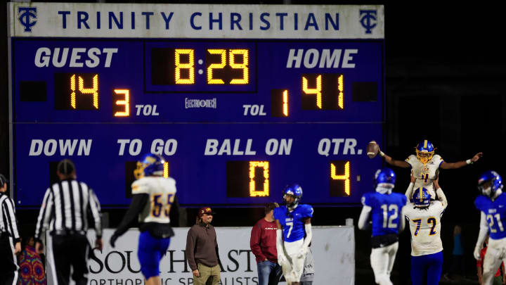 Orlando Christian Prep's Akeevin Anderson (4) scores a touchdown as Orlando Christian Prep's Demetrius Campbell (72) hoists him high during the fourth quarter of an FHSAA Region 1-1M high school football playoff matchup Friday, Nov. 24, 2023 at Trinity Christian Academy in Jacksonville, Fla. Trinity Christian Academy Conquerors defeated the Orlando Prep Warriors 48-20 and advance to the state semifinal. [Corey Perrine/Florida Times-Union]