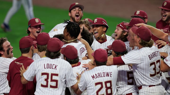 In the middle of the pack, not seen, Florida St. Seminole players mob infielder Alex Lodise (1) after hitting the game-winning grand slam during an NCAA college baseball matchup Tuesday, March 25, 2025 at VyStar Ballpark in Jacksonville, Fla. FSU rallied to defeat UF 8-4 off a walk-off grand slam from Alex Lodise in the ninth inning.