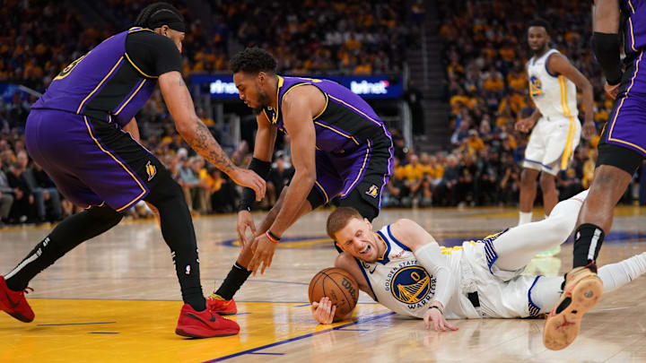 May 4, 2023; San Francisco, California, USA; Golden State Warriors guard Donte DiVincenzo (0) gains control of a loose ball next to Los Angeles Lakers guard Troy Brown Jr. (7) and forward Anthony Davis (3) in the third quarter during game two of the 2023 NBA playoffs at the Chase Center. Mandatory Credit: Cary Edmondson-Imagn Images