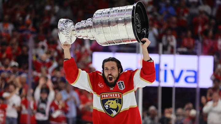 Jun 24, 2024; Sunrise, Florida, USA; Florida Panthers forward Ryan Lomberg (94) hoists the Stanley Cup after defeating the Edmonton Oilers in game seven of the 2024 Stanley Cup Final at Amerant Bank Arena. Mandatory Credit: Sam Navarro-Imagn Images