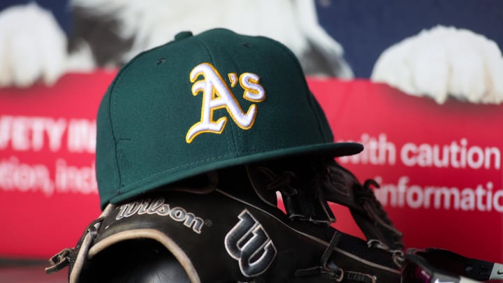 Jun 1, 2024; Atlanta, Georgia, USA; A detailed view of an Oakland Athletics hat and glove on the field against the Atlanta Braves in the sixth inning at Truist Park. Mandatory Credit: Brett Davis-USA TODAY Sports