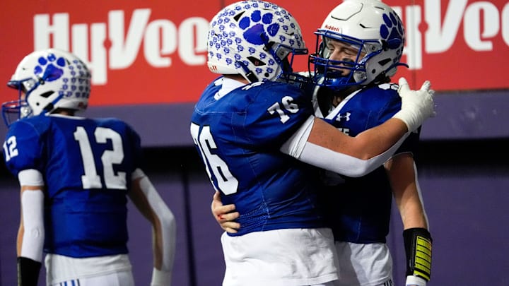 West Lyon’s Micah Van Beek (76) hugs West Lyon’s Easton DeJong (13) after DeJong scored a touchdown Nov. 20, 2025 during the Class 1A state football championship against the Iowa City Regina Regals at the UNI-Dome in Cedar Falls, Iowa.