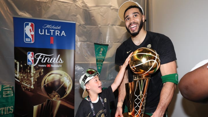 Jun 17, 2024; Boston, Massachusetts, USA; Boston Celtics forward Jayson Tatum (0) holds the Larry O’Brien Championship Trophy with his son after Boston's 106-88 win against the Dallas Mavericks after game five of the 2024 NBA Finals at TD Garden. Mandatory Credit: Elsa/Pool Photo-USA TODAY Sports