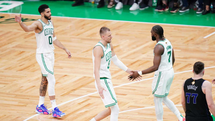 Jun 6, 2024; Boston, Massachusetts, USA; Boston Celtics center Kristaps Porzingis (8) and guard Jaylen Brown (7) and forward Jayson Tatum (0) react in the second quarter against the Dallas Mavericks during game one of the 2024 NBA Finals at TD Garden. Mandatory Credit: David Butler II-USA TODAY Sports