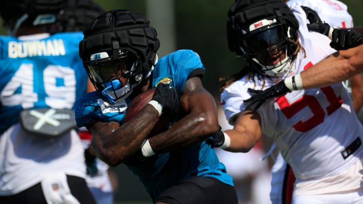 Jacksonville Jaguars running back Tank Bigsby (4) runs the ball against Tampa Bay Buccaneers linebacker J.J. Russell (51) during a combined NFL football training camp session between the Tampa Bay Buccaneers and Jacksonville Jaguars Wednesday, Aug. 14, 2024 at EverBank Stadium’s Miller Electric Center in Jacksonville, Fla. [Corey Perrine/Florida Times-Union]