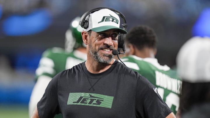 Aug 17, 2024; Charlotte, North Carolina, USA; New York Jets quarterback Aaron Rodgers (8) shares a laugh on the sidelines during the second half against the Carolina Panthers at Bank of America Stadium.