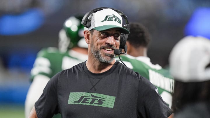 New York Jets quarterback Aaron Rodgers shares a laugh on the sidelines during the second half against the Carolina Panthers on Aug. 17, 2024.