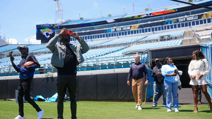 Jacksonville Jaguars wide receiver Brian Thomas Jr., center left, photographs as he enters the field