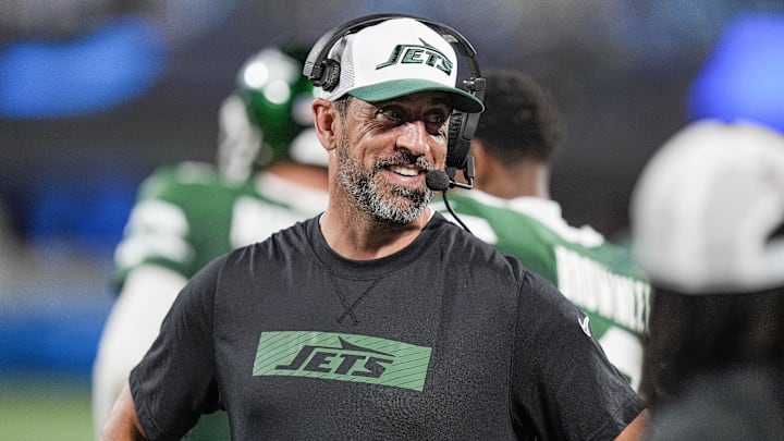 Aug 17, 2024; Charlotte, North Carolina, USA;  New York Jets quarterback Aaron Rodgers (8) shares a laugh on the sidelines during the second half against the Carolina Panthers at Bank of America Stadium. Mandatory Credit: Jim Dedmon-Imagn Images