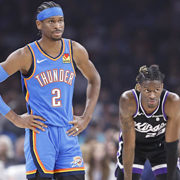 Apr 9, 2024; Oklahoma City, Oklahoma, USA; Oklahoma City Thunder guard Shai Gilgeous-Alexander (2) and Sacramento Kings guard Keon Ellis (23) during a break in play during the first quarter at Paycom Center. Mandatory Credit: Alonzo Adams-Imagn Images