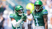 Aug 30, 2025; New Orleans, Louisiana, USA;  Tulane Green Wave defensive back Jahiem Johnson (20) and Tulane Green Wave safety Jack Tchienchou (1) react to a play against Northwestern Wildcats during the second half at Yulman Stadium. Mandatory Credit: Stephen Lew-Imagn Images