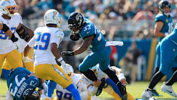Jacksonville Jaguars running back Bhayshul Tuten (33) is tackled by Los Angeles Chargers cornerback Elijah Molden (2) during the first quarter of an NFL football game at EverBank Stadium, Sunday, Nov. 16, 2025 in Jacksonville, Fla.