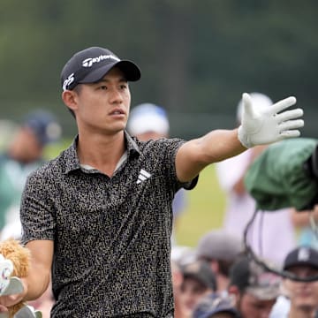 Collin Morikawa and his caddie plan a shot