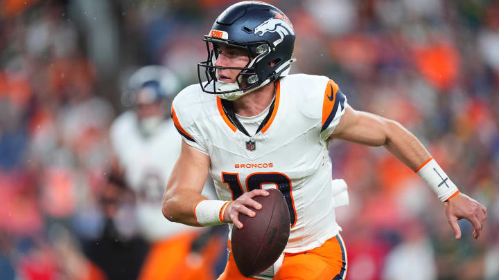 Denver Broncos quarterback Bo Nix (10) scrambles with the ball in the first quarter against the Green Bay Packers at Empower Field at Mile High.